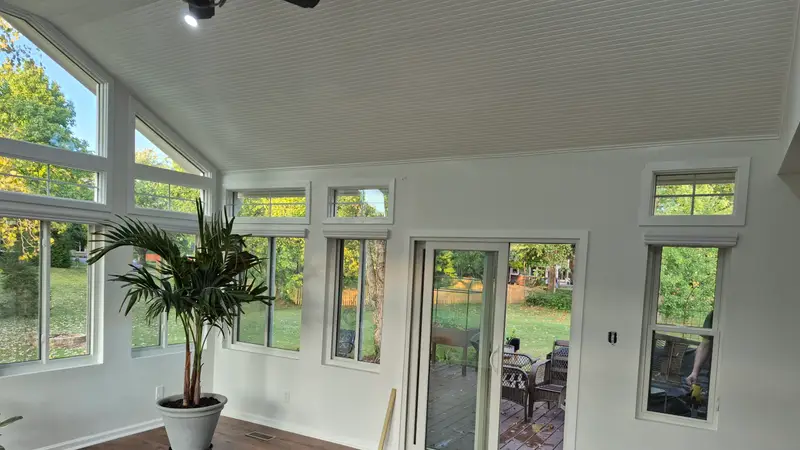 Sunroom addition with vaulted ceiling, wall of windows and wood floors